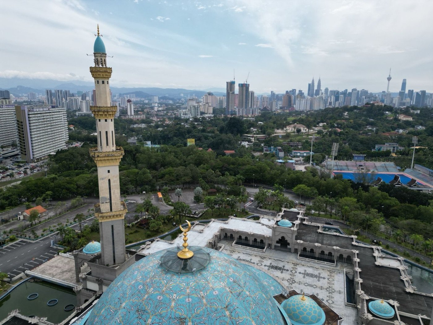 Federal Territory Mosque with the Kuala Lumpur skyline behind it