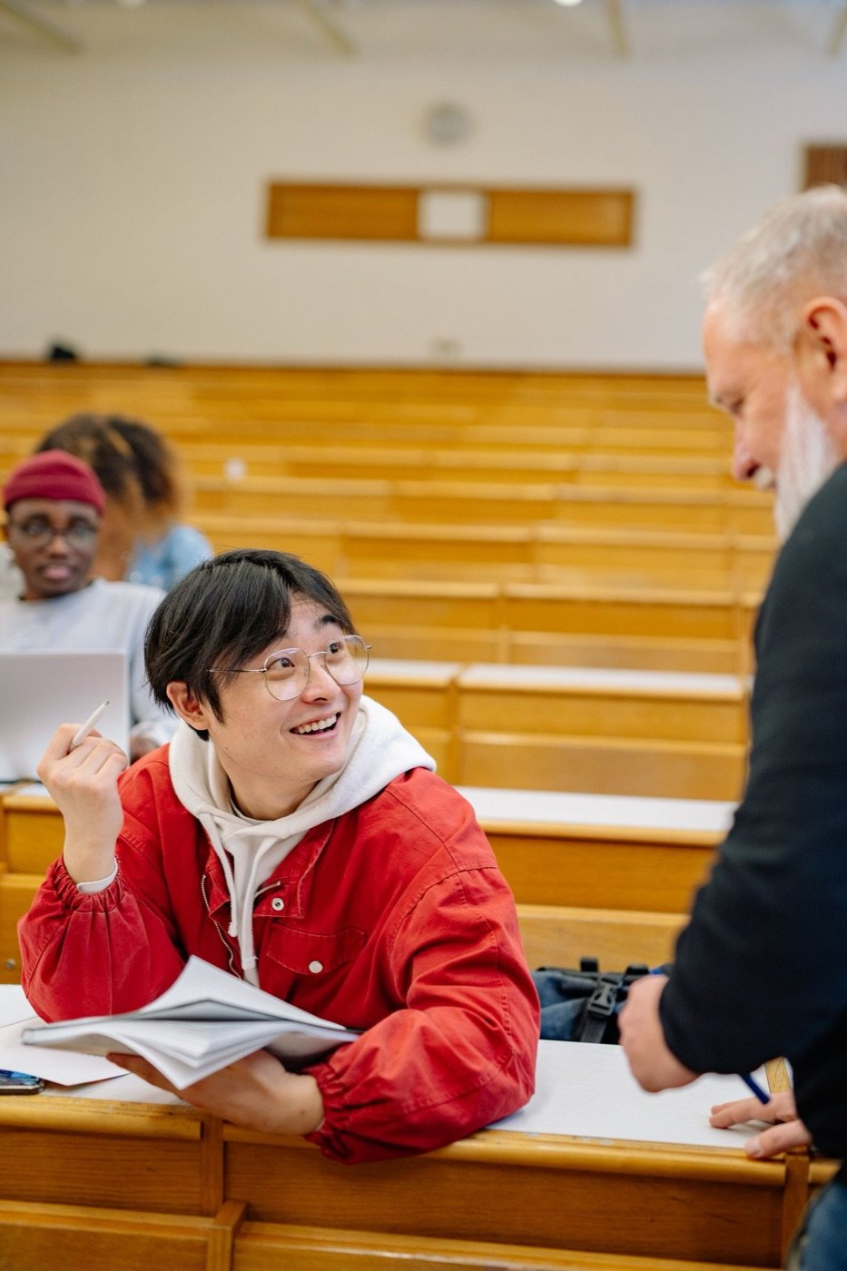 A student talking with his professor in a lecture hall